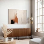 Abstract beige wall art with modern wooden credenza in minimalist living room interior.