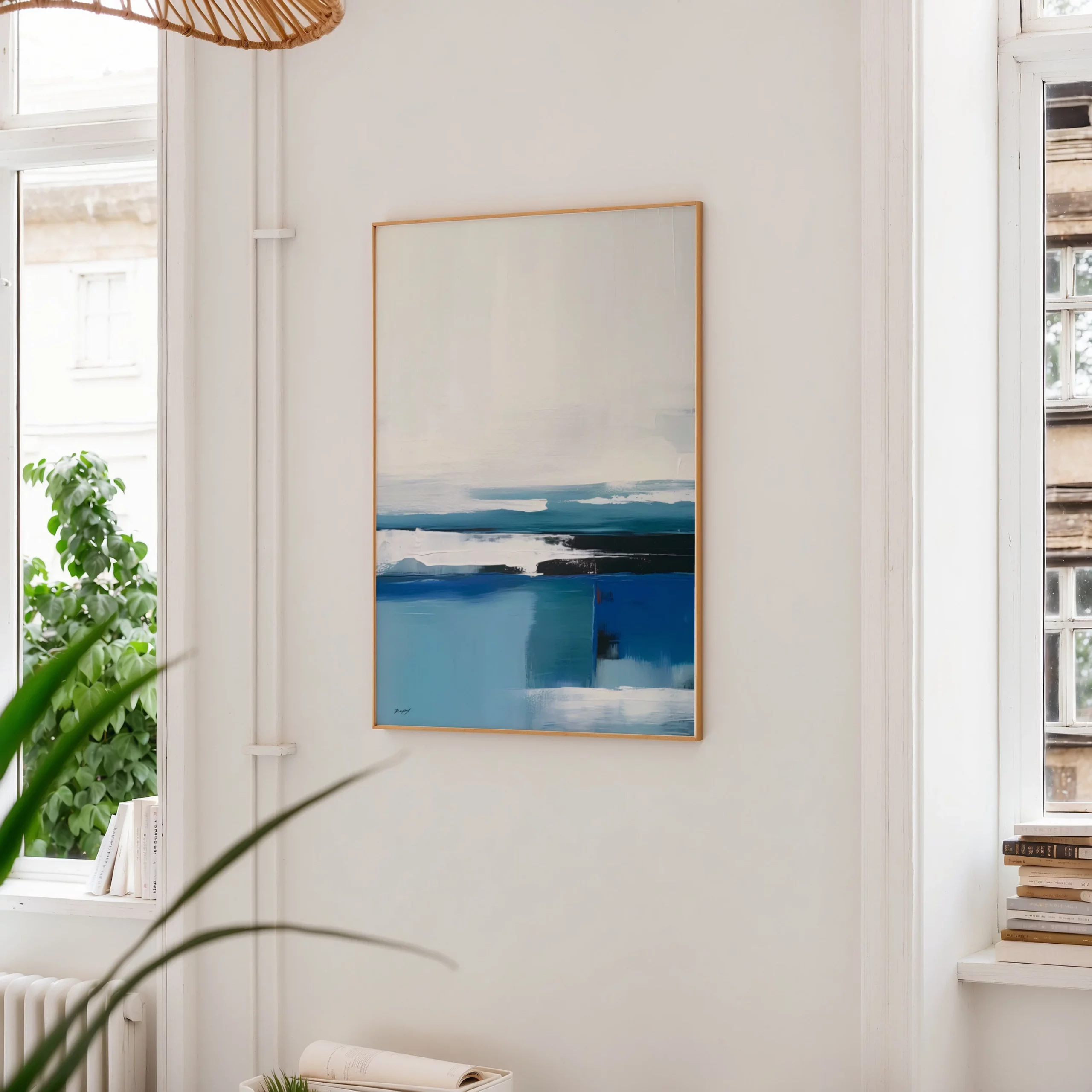 Abstract blue ocean painting in minimalist interior with plant and wooden bookshelf.