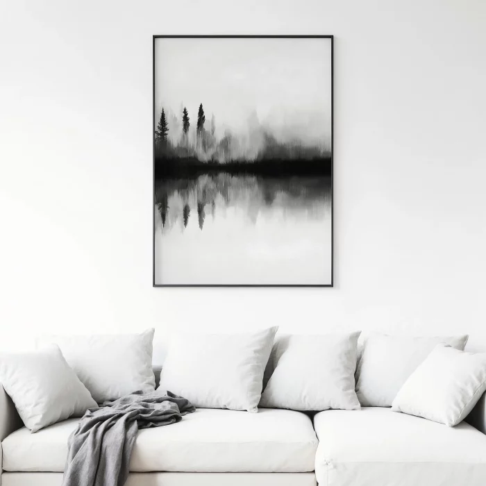 Misty forest reflection artwork in black and white above minimalist white sofa.