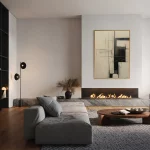 Minimalist living room with gray sectional, fireplace, and abstract wall art.