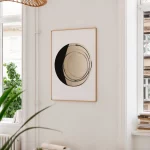 Minimalist black and beige zen circle artwork in wooden frame against white wall