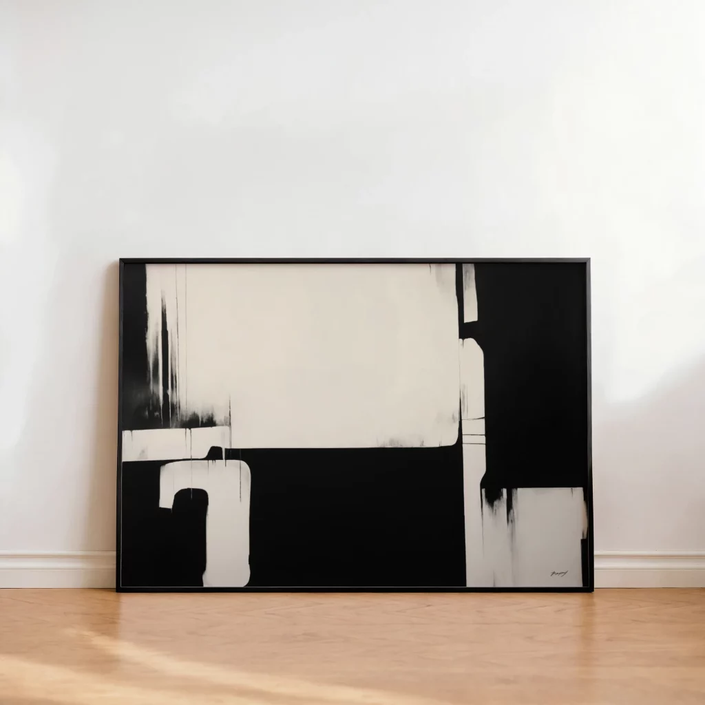 Minimalist black and white abstract painting leaning against white wall on wooden floor.