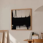 Abstract black brushstroke artwork on light wall with wooden shelf and stacked books.