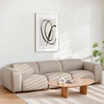 Abstract black line art over beige sectional sofa in minimalist living room.