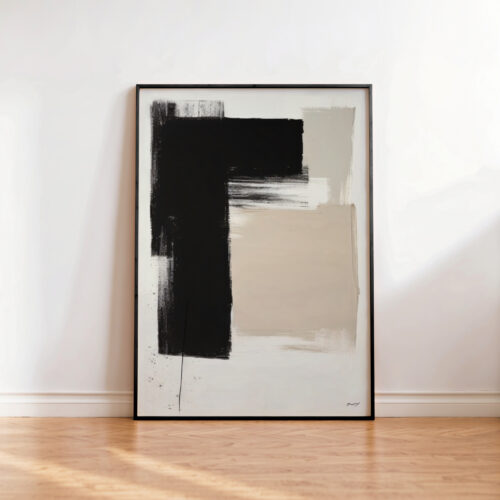 Abstract geometric artwork with black and beige shapes leaning against white wall.