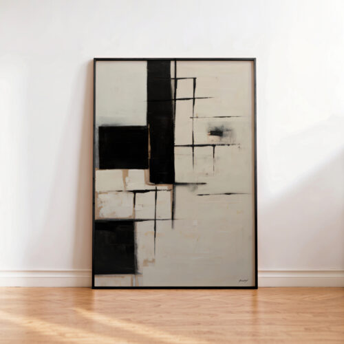 Black and white geometric abstract artwork framed against white wall on wooden floor.