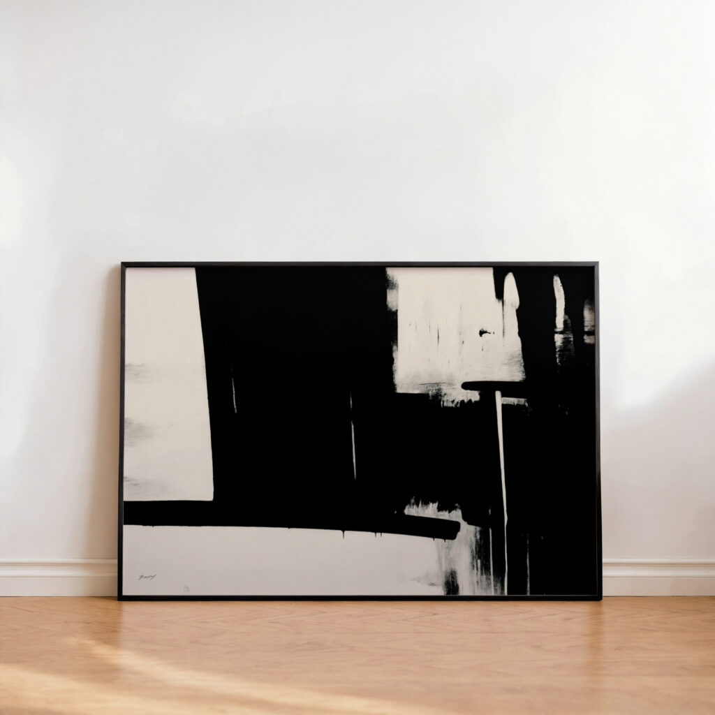 Minimalist black and white abstract artwork with bold brushstrokes leaning against white wall.