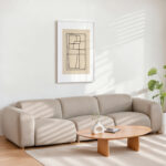 Minimalist living room with beige sectional sofa, round coffee table and abstract line art.