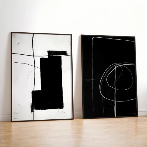 Two minimalist abstract artworks in black and white geometric patterns with thin black frames.