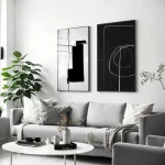 Minimalist living room with black and white abstract art above gray sofa.