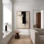 Minimalist living room featuring black and beige abstract geometric artwork above wooden side table.