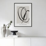 Minimalist black brushstroke art with white vase and decor on modern cabinet.