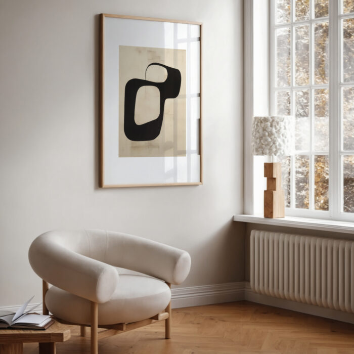 Modern minimalist living room with abstract black and beige artwork above curved armchair.