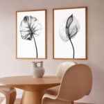 Minimalist dining space with framed botanical X-ray prints above wooden table.