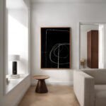 Abstract black and white line art in minimalist white living room with wooden accents.