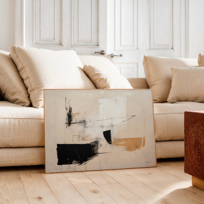 Abstract minimalist painting with beige and black tones against neutral living room interior.
