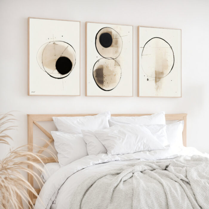 Minimalist abstract circular artwork triptych above bed in serene neutral bedroom