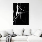 Bold abstract black and white artwork above white sofa in minimalist living space.