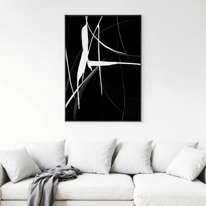 Bold abstract black and white artwork above white sofa in minimalist living space.