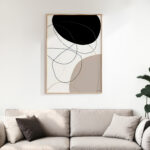Minimalist abstract wall art with curved black and beige lines above neutral sofa.