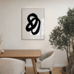 Elegant dining area with bold black abstract art, wooden table, and green plant.