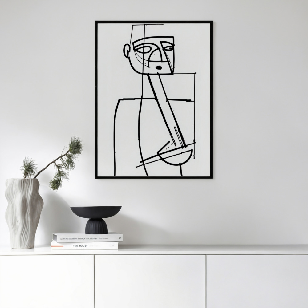 Minimalist black line art in frame above white cabinet with decorative vase and books.