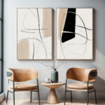 Abstract black and beige diptych art above mid-century chairs with small accent table.