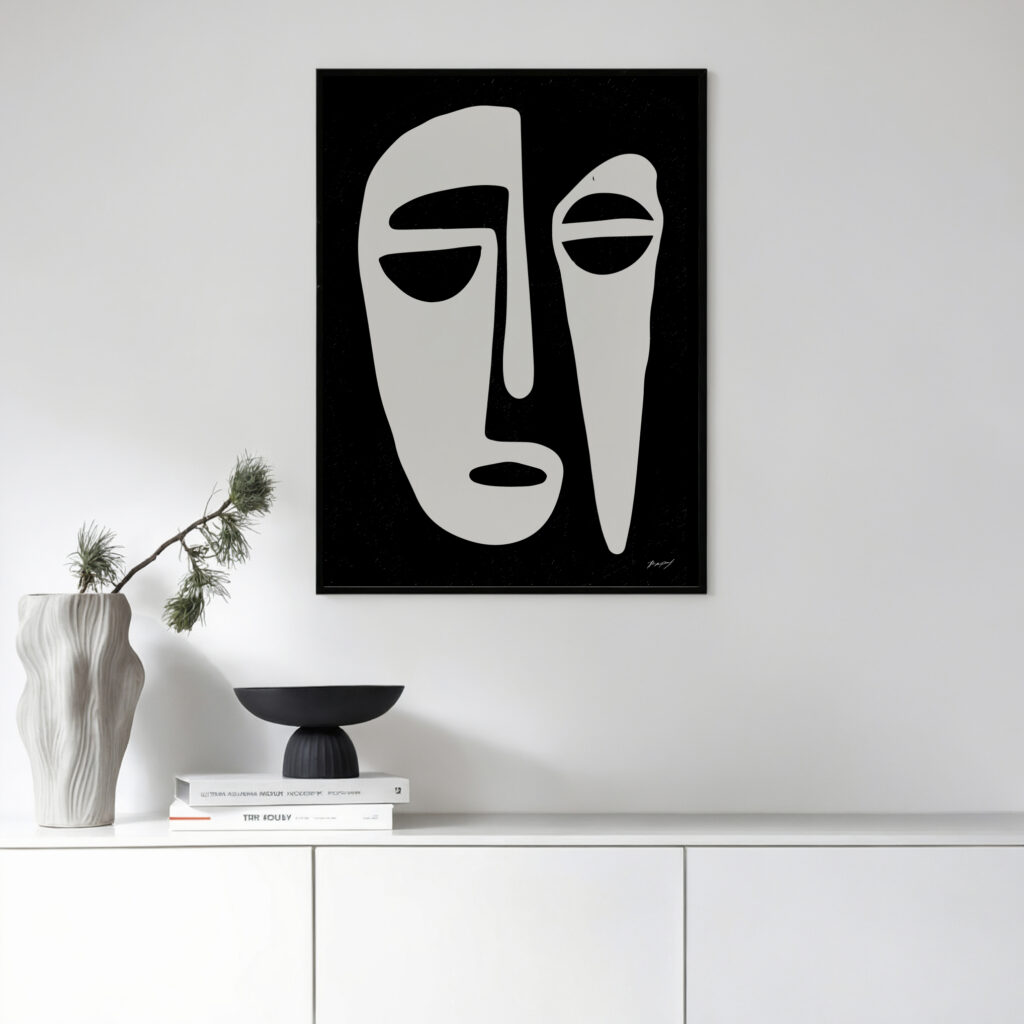 Abstract minimalist face artwork in black and white, displayed above modern white sideboard with decorative items.