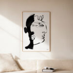 Minimalist black ink line art portrait showing abstract face profile displayed in wooden frame