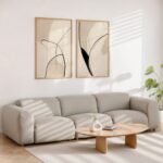 Elegant abstract line art displayed above gray sectional sofa in minimalist living room.