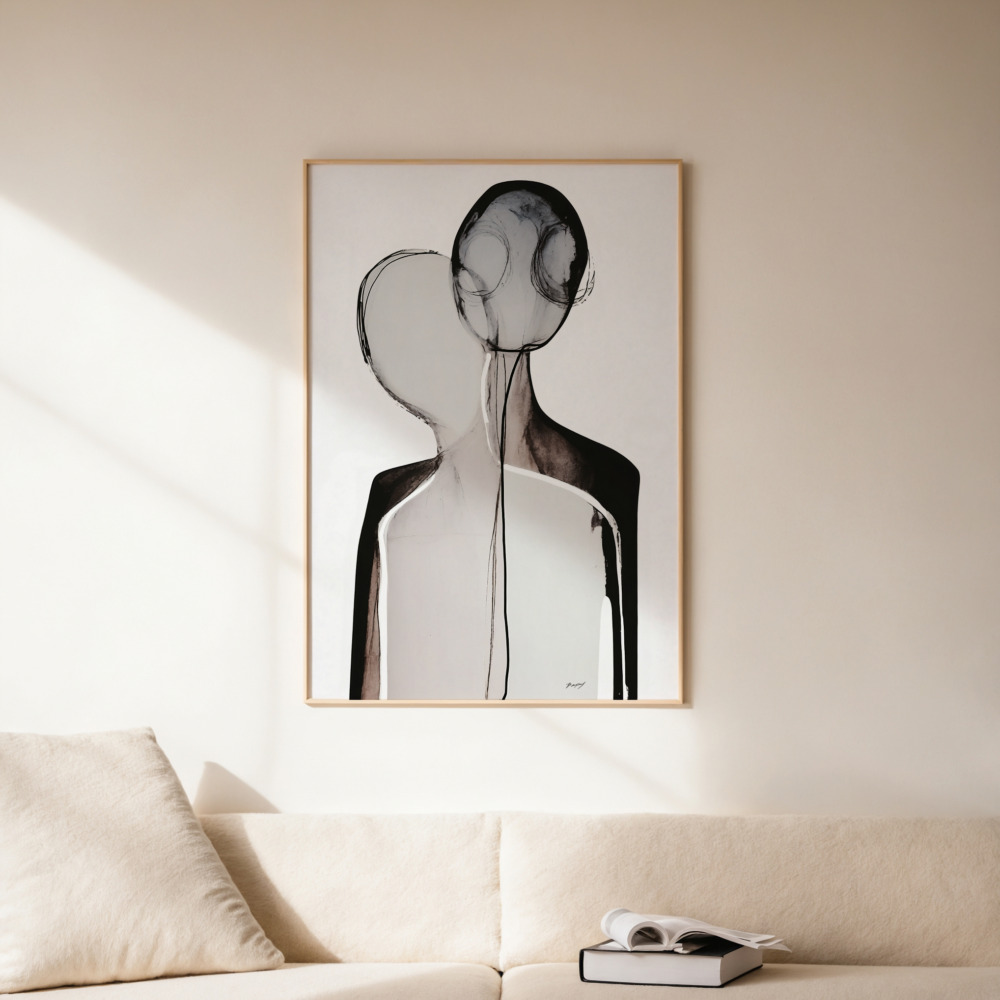 Black abstract figure artwork framed on cream wall above neutral sofa.