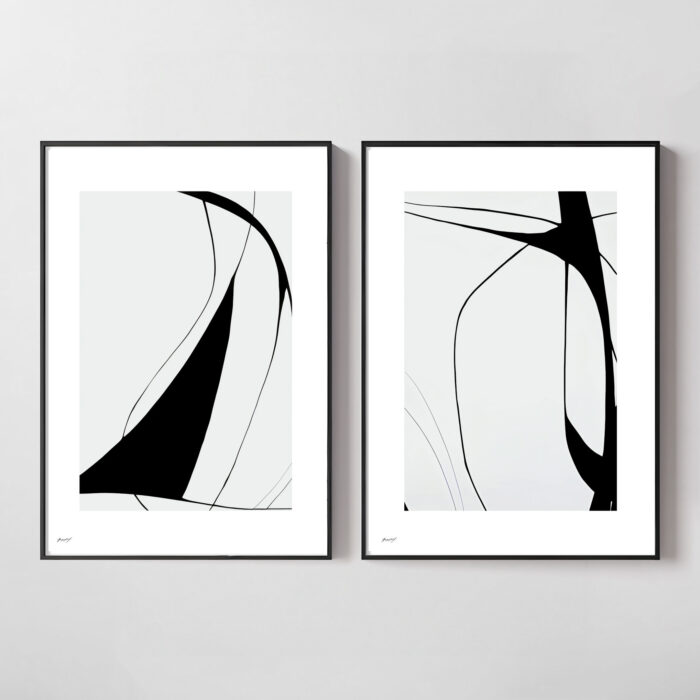 Minimalist black and white abstract art pair in thin frames on white wall.