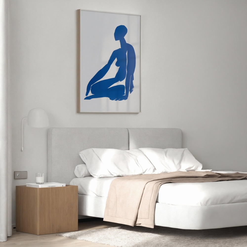 Blue silhouette artwork above platform bed with wooden nightstand in minimalist bedroom.