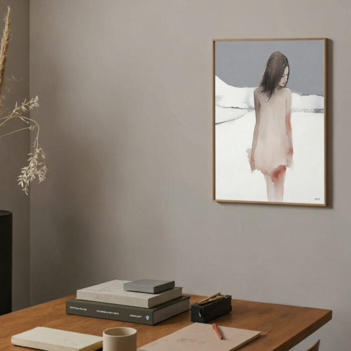 Elegant minimalist workspace with framed abstract artwork and natural elements on wooden desk.