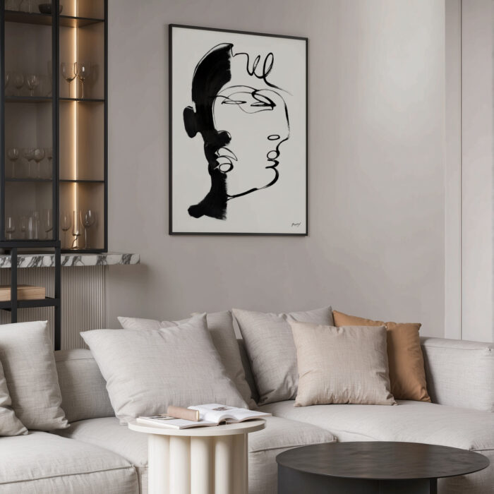 Minimalist black and white portrait art above neutral sectional sofa in modern living room.