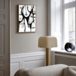 Modern living room featuring abstract black and white brushstroke artwork on light gray wall.
