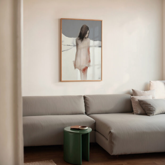 Minimalist living room featuring gray sectional sofa with abstract wall art and green accent table.