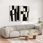 Modern living room with black and white geometric art above gray sectional sofa.