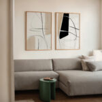 Abstract wall art prints above gray sectional sofa in modern living room