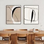 Abstract wall art duo above wooden dining table with six chairs.