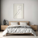 Minimalist bedroom with sleek wooden bed frame and simple line art portrait above headboard.