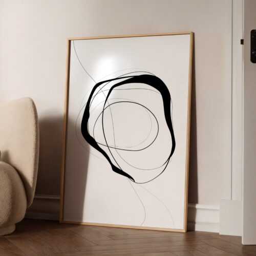 Minimalist black brushstroke abstract art in wooden frame against white wall