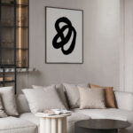 Minimalist living room with abstract black knot artwork over white sectional sofa.