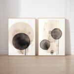 Abstract wabi-sabi art prints with black dripping circles on beige backgrounds in wooden frames.