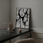 Abstract black ink artwork with decorative objects on dark marble console