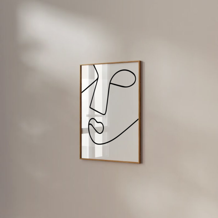 Minimalist line drawing of abstract face profile in wooden frame on light wall