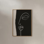 Minimalist white line face drawing on black background in simple wooden frame.