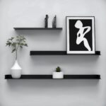 Three black floating shelves with minimalist decor and black and white wall art.