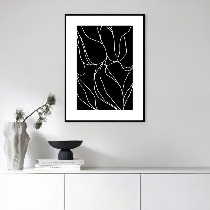 Minimalist black and white floral line art in sleek frame above white cabinet