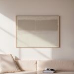 Minimalist abstract painting in neutral tones hanging above a cozy beige sofa.